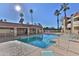 Palm trees tower over a community pool surrounded by lounge chairs and tables at 12123 W Bell Rd # 118, Surprise, AZ 85378