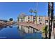 Waterfront living features palm trees and lush foliage surrounding the buildings and a bridge at 12123 W Bell Rd # 118, Surprise, AZ 85378