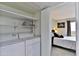 Functional laundry room with washer, dryer, storage shelves, and entrance to bedroom at 12123 W Bell Rd # 218, Surprise, AZ 85378