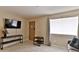 Cozy living room featuring a TV, console table, neutral wall color, and large window at 12123 W Bell Rd # 218, Surprise, AZ 85378