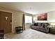 Comfortable living room with a gray couch, artwork, neutral wall color, and a large window at 12123 W Bell Rd # 218, Surprise, AZ 85378