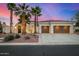 Beautiful single Gathering home featuring a three car garage, desert landscaping, and palm trees at 13207 W Santa Ynez Dr, Sun City West, AZ 85375