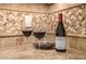 A bottle of wine sits on the granite countertop in front of a backsplash with wine glasses nearby at 13207 W Santa Ynez Dr, Sun City West, AZ 85375