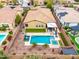 Backyard oasis featuring a sparkling pool, spa, patio, and lush landscaping perfect for outdoor entertaining at 14906 W Luna N Dr, Litchfield Park, AZ 85340