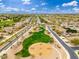 An aerial view of a residential area with a basketball court and green space in the center with palm trees at 14906 W Luna N Dr, Litchfield Park, AZ 85340