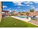 Resort style backyard featuring a pool, spa, putting green, lounge chairs and outdoor living area at 14906 W Luna N Dr, Litchfield Park, AZ 85340