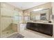 Bright bathroom featuring double sinks, shower, and a soaking tub under a window at 14906 W Luna N Dr, Litchfield Park, AZ 85340