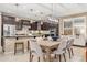 Modern kitchen with dark wood cabinets, granite countertops, stainless steel appliances, and an adjacent dining area at 14906 W Luna N Dr, Litchfield Park, AZ 85340