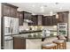 Gourmet kitchen with dark cabinetry, granite countertops, stainless steel appliances, and a convenient breakfast bar at 14906 W Luna N Dr, Litchfield Park, AZ 85340