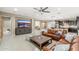 Bright, open living room featuring a leather sofa, ceiling fan, and a large TV with scenic views displayed at 14906 W Luna N Dr, Litchfield Park, AZ 85340