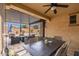 Covered outdoor patio with dining area and lounge seating overlooking backyard pool and putting green at 14906 W Luna N Dr, Litchfield Park, AZ 85340