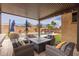 Covered patio area with comfortable lounge seating and gas fire pit overlooking the backyard pool at 14906 W Luna N Dr, Litchfield Park, AZ 85340