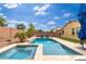 Backyard pool and spa combo lined with palm trees and lounge chairs creating the perfect outdoor oasis at 14906 W Luna N Dr, Litchfield Park, AZ 85340