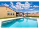 Backyard pool and patio with outdoor kitchen area and covered patio with lounge furniture at 14906 W Luna N Dr, Litchfield Park, AZ 85340