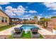 Backyard oasis featuring a pool, lounge chairs, turf, and outdoor seating area at 14906 W Luna N Dr, Litchfield Park, AZ 85340