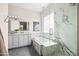 Elegant bathroom featuring marble shower, soaking tub, and a white double vanity at 1528 E Harrison St, Gilbert, AZ 85295