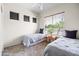 Bedroom featuring neutral walls, carpeted floors, ceiling fan, and multiple windows at 1528 E Harrison St, Gilbert, AZ 85295
