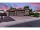 Charming home featuring a three-car garage and tidy front yard, all beneath a colorful evening sky at 1528 E Harrison St, Gilbert, AZ 85295