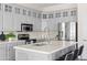 Updated kitchen features gray cabinets, quartz countertops, stainless appliances, and an island with bar seating at 1528 E Harrison St, Gilbert, AZ 85295