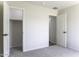 Bedroom showcases an open closet and doorway, complemented by gray carpet and neutral walls for a modern aesthetic at 16010 S Elizabeth Pl, Arizona City, AZ 85123