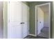 Hallway with vinyl floors has double doors to storage and another doorway, with neutral wall colors at 16010 S Elizabeth Pl, Arizona City, AZ 85123