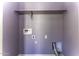 Compact laundry room with utility connections and a shelf for supplies, painted in a calming purple shade at 16010 S Elizabeth Pl, Arizona City, AZ 85123