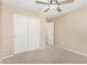 Comfortable bedroom features a ceiling fan, neutral carpeting, and a closet with sliding doors at 16508 N 114Th Dr, Surprise, AZ 85378