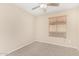 This bedroom features a ceiling fan, neutral carpeting, and a window that lets in natural light at 16508 N 114Th Dr, Surprise, AZ 85378