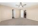 Inviting bedroom features a ceiling fan, neutral carpeting, and two open doorways at 16508 N 114Th Dr, Surprise, AZ 85378