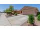 A tan single-story home on a sunny day, highlighting the two-car garage and neat landscaping at 16508 N 114Th Dr, Surprise, AZ 85378