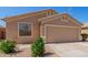 Tan single-story home with a two-car garage and desert landscaping on a bright, sunny day at 16508 N 114Th Dr, Surprise, AZ 85378