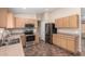 Functional kitchen featuring stainless steel appliances, wood cabinets, and tile flooring at 16508 N 114Th Dr, Surprise, AZ 85378