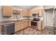Bright kitchen with stainless steel appliances, wood cabinets, a sink with a view, and tile floors at 16508 N 114Th Dr, Surprise, AZ 85378