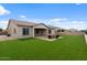 Landscaped backyard features a fire pit with seating on a paver patio and artificial turf at 19372 E Timberline Rd, Queen Creek, AZ 85142