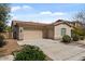 Exterior view of a home showcasing a three-car garage, desert landscaping, and a red tile roof at 19372 E Timberline Rd, Queen Creek, AZ 85142