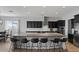 Modern kitchen with a large island, barstool seating, dark cabinets, and stainless steel appliances at 19372 E Timberline Rd, Queen Creek, AZ 85142