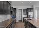 Modern kitchen with granite countertops, dark cabinets, stainless steel appliances, and a walk-in pantry at 19372 E Timberline Rd, Queen Creek, AZ 85142