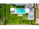 Breathtaking aerial view of a backyard featuring a sparkling pool, sports court, lush green lawn, and manicured landscaping at 20690 E Sunset Dr, Queen Creek, AZ 85142