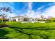 A lush green backyard, featuring a pool and an outdoor kitchen area at 20690 E Sunset Dr, Queen Creek, AZ 85142