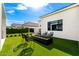 Lush backyard boasts a modern fire pit with seating, framed by green turf and a beautiful exterior at 20690 E Sunset Dr, Queen Creek, AZ 85142