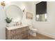 Stylish powder room features a carved wood vanity, round mirror, and modern fixtures at 20690 E Sunset Dr, Queen Creek, AZ 85142