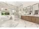 A stylish bathroom featuring marble floors and walls, dual sinks, soaking tub and a glass enclosed shower at 20690 E Sunset Dr, Queen Creek, AZ 85142