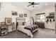 Nicely decorated bedroom with a bed, black metal bed frame, ceiling fan, desk, and wall art at 20690 E Sunset Dr, Queen Creek, AZ 85142
