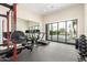 Bright home gym with a treadmill, stationary bike, weight rack and access to an outdoor patio at 20690 E Sunset Dr, Queen Creek, AZ 85142
