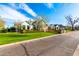 Beautiful exterior view of a single-Gathering home with a large lawn, mature landscaping, and brick driveway at 20690 E Sunset Dr, Queen Creek, AZ 85142