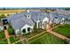 Elegant white brick home with lush landscaping, green lawn and brick pathway, beautifully captured from an aerial view at 20690 E Sunset Dr, Queen Creek, AZ 85142