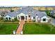 Stunning aerial view of a grand white brick home, showcasing its manicured lawn, lush landscaping and brick pathway at 20690 E Sunset Dr, Queen Creek, AZ 85142