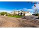 Exterior view with lush landscaping showing manicured lawn, brick driveway, and attached garages on a sunny day at 20690 E Sunset Dr, Queen Creek, AZ 85142