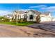 Exterior view with lush landscaping showing manicured lawn, brick driveway, and attached garages at 20690 E Sunset Dr, Queen Creek, AZ 85142