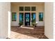 Elegant front entrance with brick flooring, black front door, and decorative plants creating a grand entry at 20690 E Sunset Dr, Queen Creek, AZ 85142